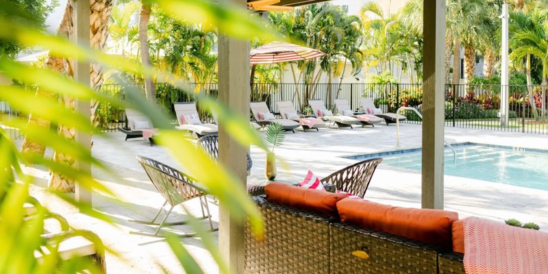 Poolside seating area with tropical plants and sun loungers