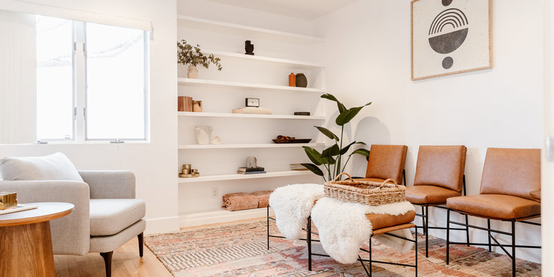 Cozy lounge with warm-toned decor, built-in shelving, and soft lighting.