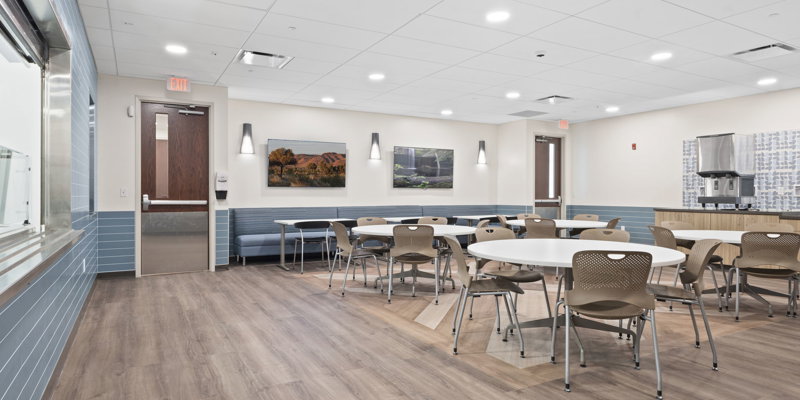 A clean, modern dining area with tables and chairs.