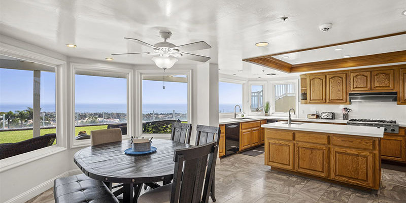 Spacious kitchen and dining area with wooden cabinets and ocean views.