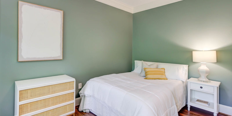 Twin bed with green accent wall and nightstand.