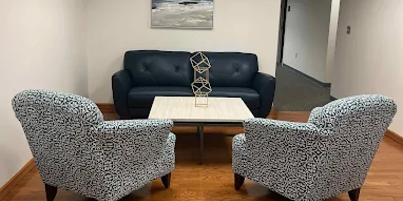 Small seating area with sofa, chairs, and modern decor