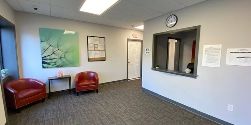 Reception area with wall art and  waiting chairs.