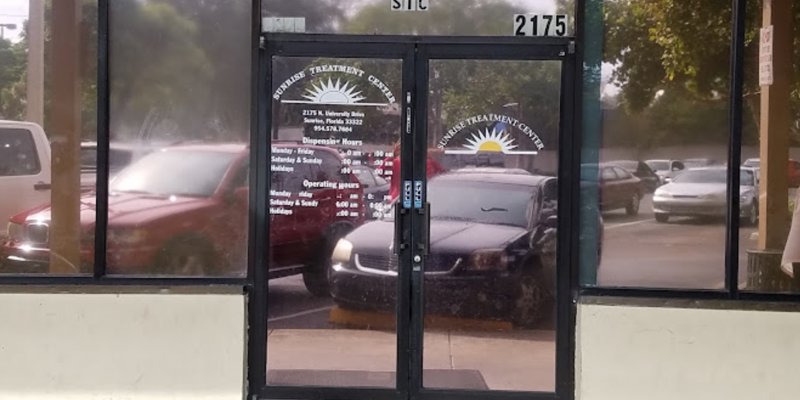 Entrance with signage and parking.