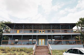 Two-story facility building with wooden staircase and porch