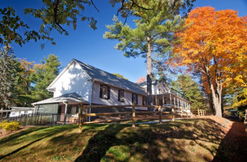 White two-story building with windows and trees