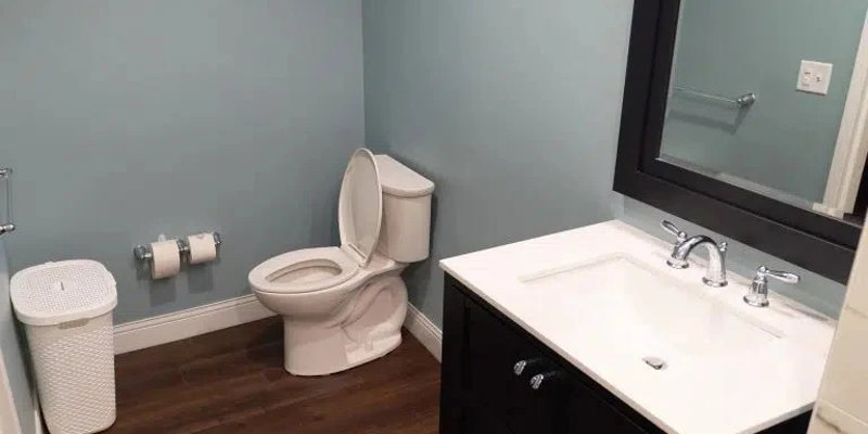 Modern bathroom with vanity and toilet on wood flooring