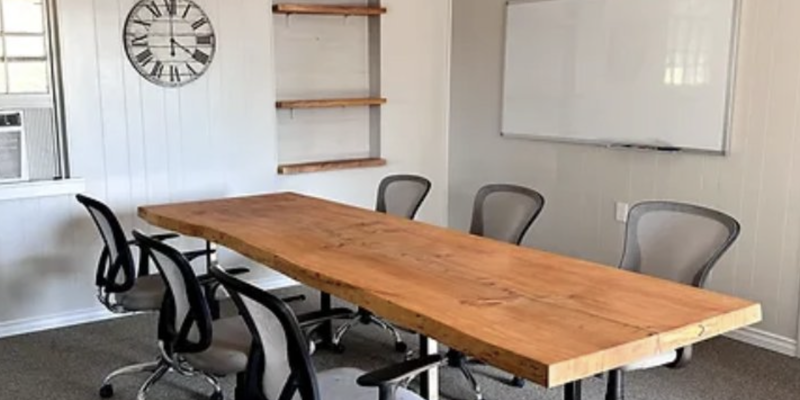 Dining area featuring a long table, whiteboard, and chairs.
