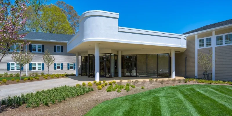 Facility entrance with paved walkway by the lawn.