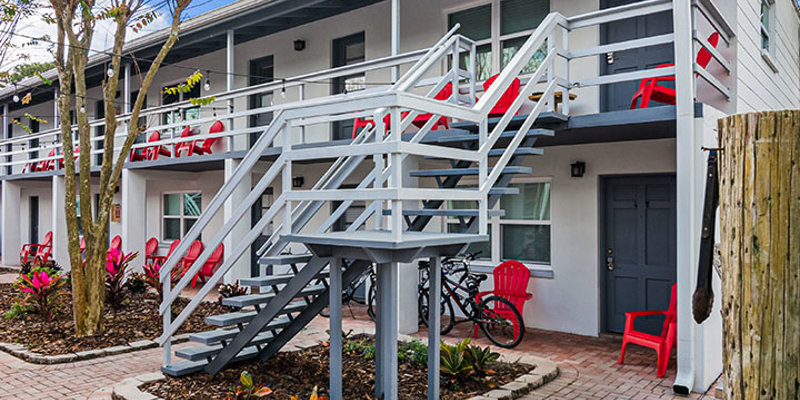 Facility exterior with two floors and stairs to entrance.
