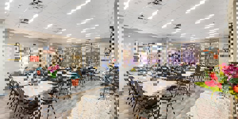 Spacious dining area with tables, chairs, and floral centerpieces