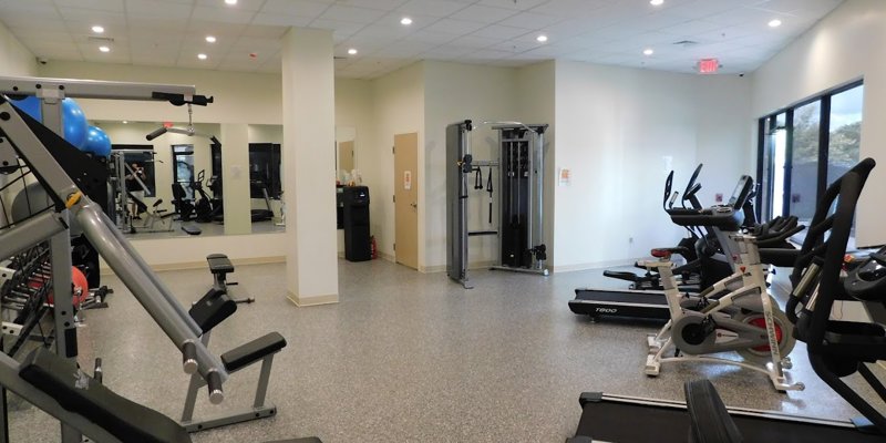 Gym with exercise equipment, treadmills, and weight machines.