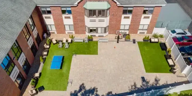 Outdoor courtyard with seating and a ping pong table.