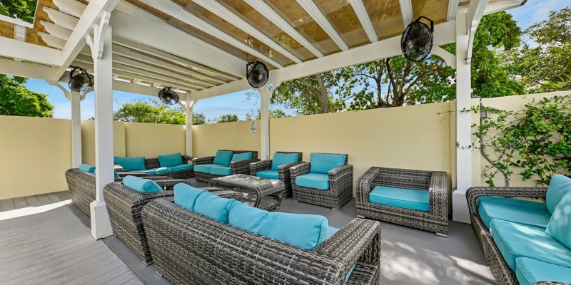 Shaded outdoor group lounge with large sofas.