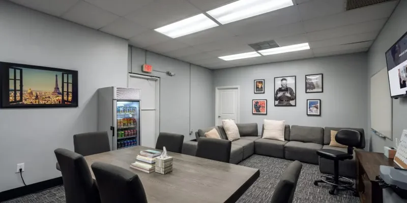 Large meeting room with couches, framed art, and a mini fridge