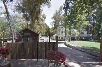 A peaceful and secluded ranch-style rehab facility surrounded by tall trees, offering a tranquil and private environment for recovery.
