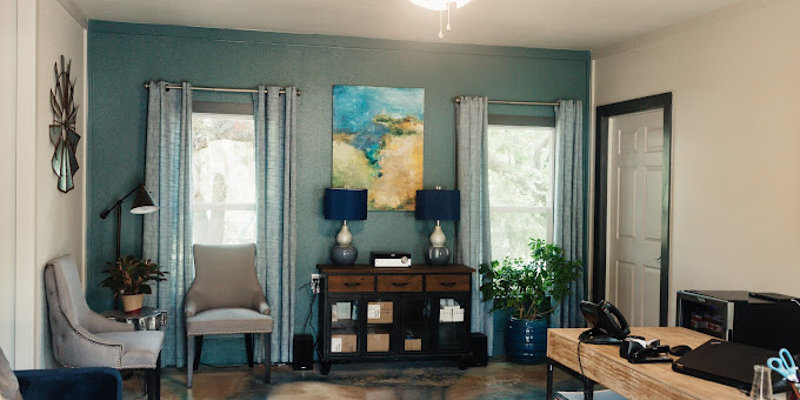 Therapy office with desk, chairs, and soft decor