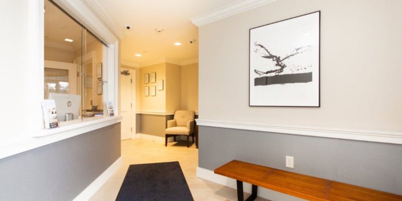 Lobby with  chairs, reception desk window.