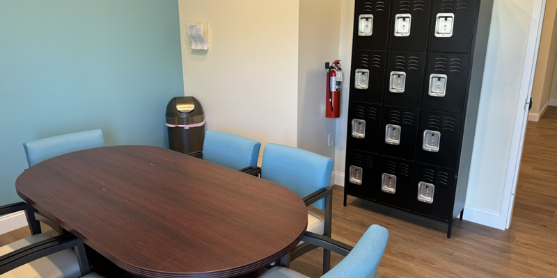 Meeting room with table, chairs, and lockers in back