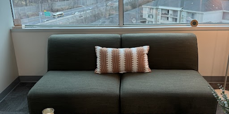 Modern lounge with a couch and cityscape view.