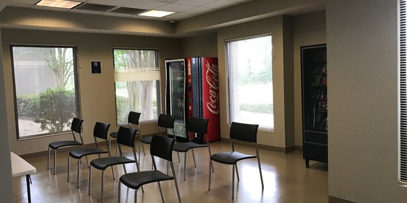 Break room with chairs, vending machines, and large windows.