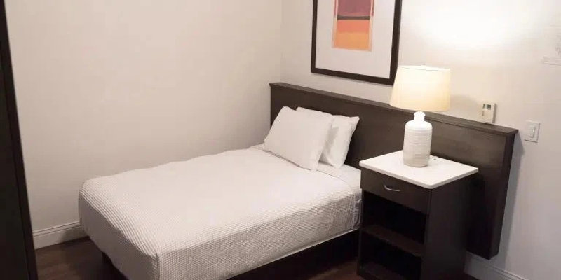Single bed with nightstand and framed wall art