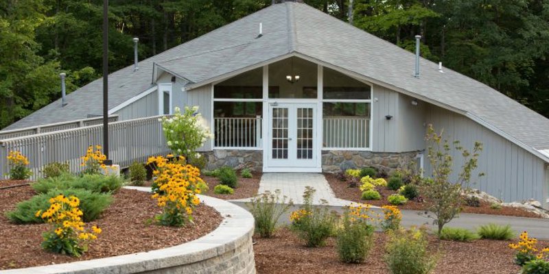 Exterior of a residential recovery facility with a landscaped front yard and flower beds in Canterbury