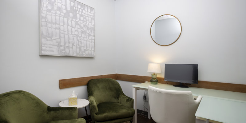 Green chairs and desk with computer in a private office