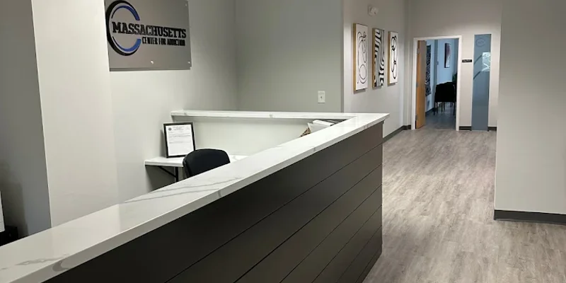 Reception desk at Massachusetts Center for Addiction with hallway and interior signage