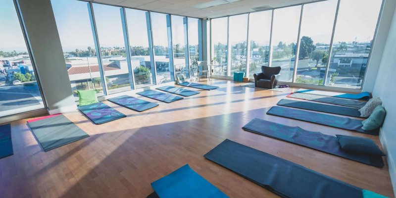 Yoga studio with large windows and mats.