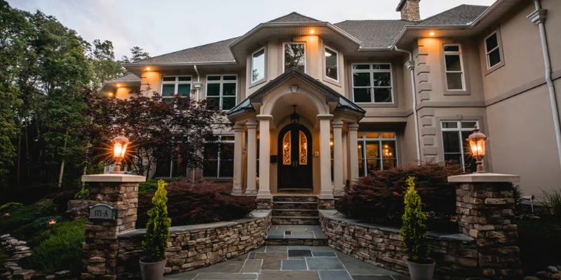 Elegant two-story home with stone entryway and porch lighting