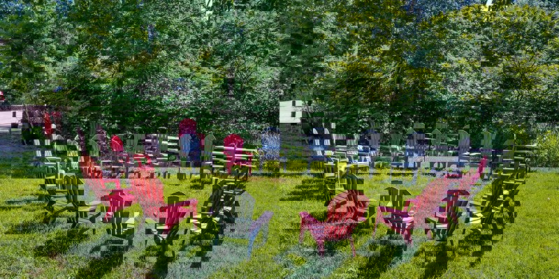 Circle of red and gray chairs on green grass