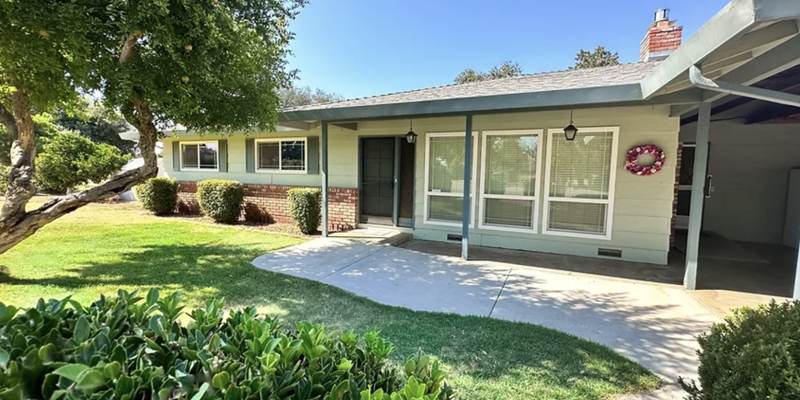Outdoor unit view with landscaped yard paved to entrance.