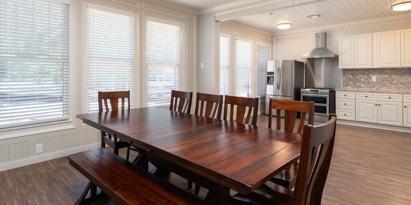 Dining area with a table, seating, and a kitchen.