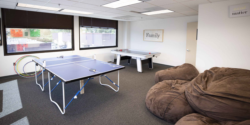 Recreation room with a ping pong table and bean bags..