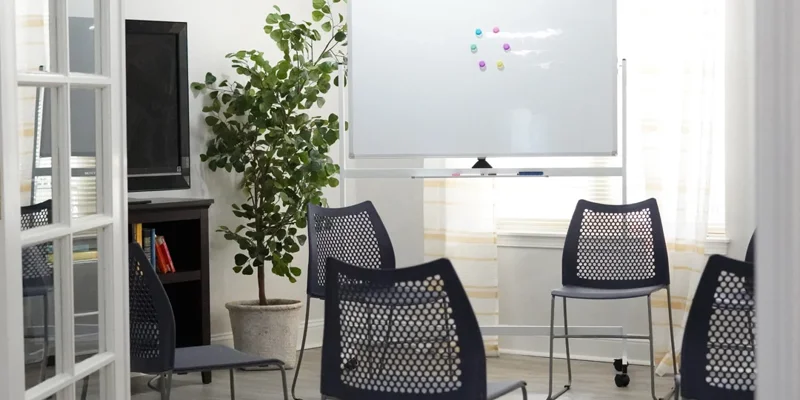 Circle of chairs and whiteboard for sessions