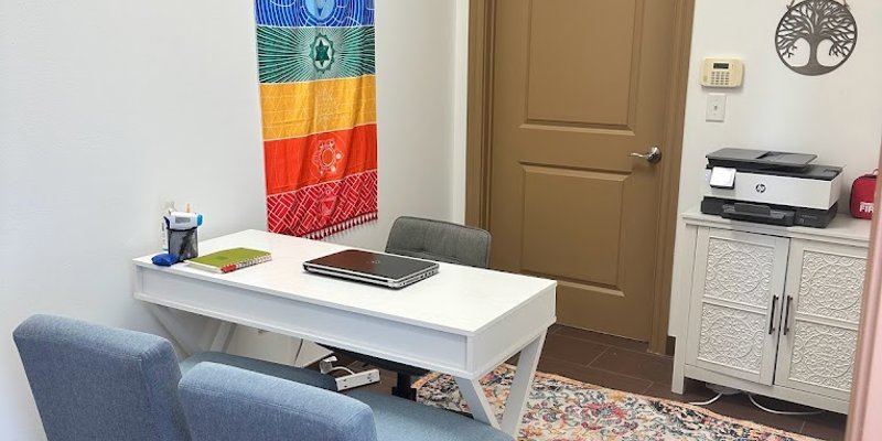 Cozy office space with a white desk and two chairs.