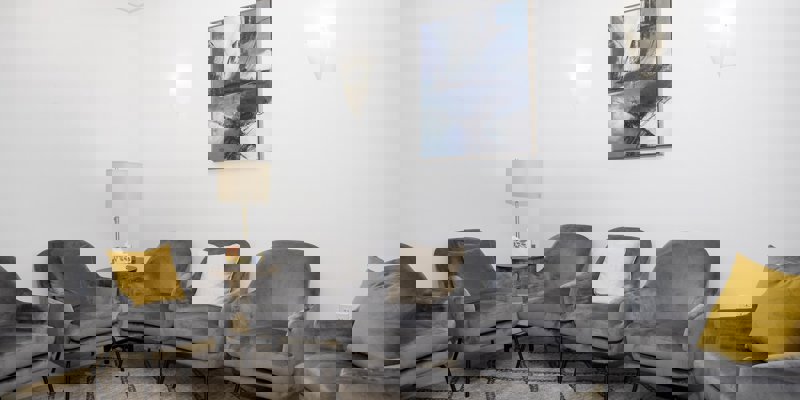  group therapy room with modern gray armchairs and abstract wall art