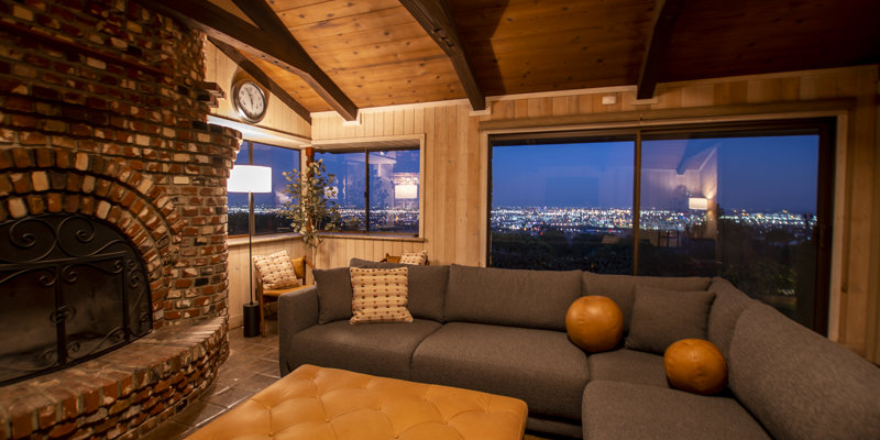Cozy lounge with a brick fireplace, city lights visible at night