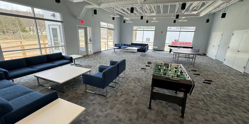 Recreational room with seating, foosball, and ping-pong tables.