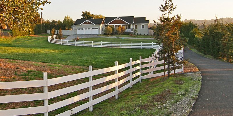 Facility driveway with a white picket fence,.