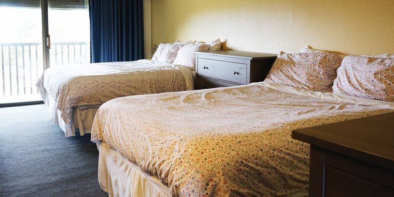 A cozy rehab bedroom with two beds and a sliding door.