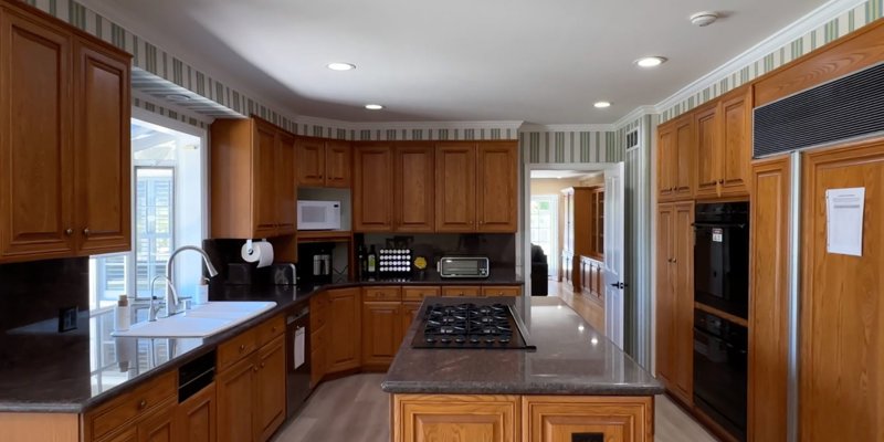 A spacious kitchen with wooden cabinetry and a center island.