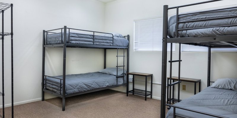 Dorm-style room with bunk beds and gray bedding