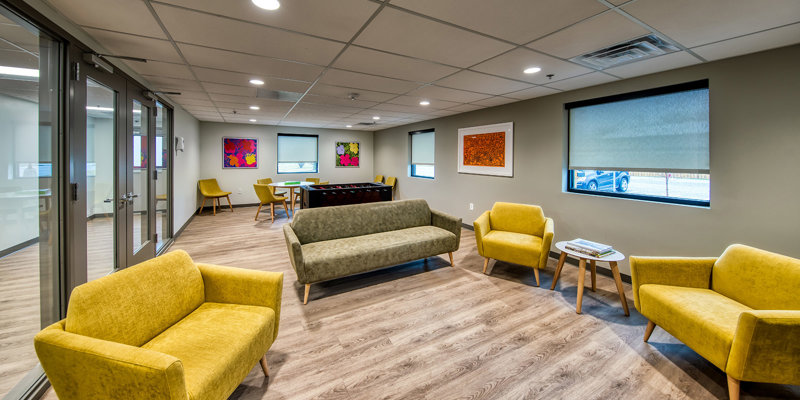 Room with football machine, colorful chairs, and art