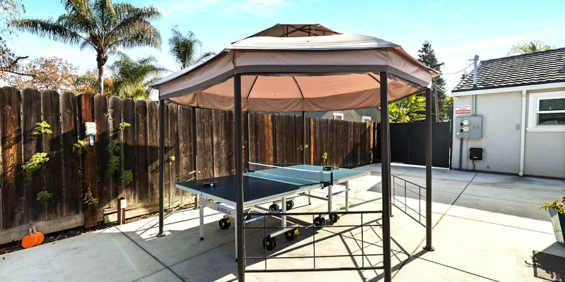 Ping pong table under canopy on concrete patio